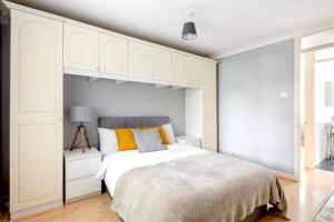 - une chambre avec un grand lit blanc et des oreillers orange dans l'établissement Eagle Drive, à Hendon