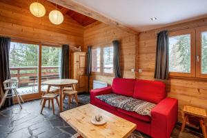 salon z czerwoną kanapą i stołem w obiekcie Maison de 4 chambres a Montvalezan a 700 m des pistes avec jardin amenage et wifi w mieście Montvalezan