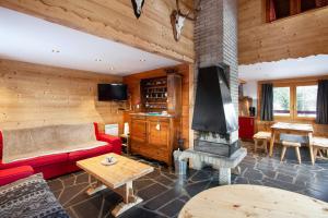 a living room with a red couch and a fireplace at Maison de 4 chambres a Montvalezan a 700 m des pistes avec jardin amenage et wifi in Montvalezan