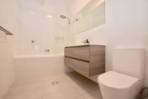 a bathroom with a toilet and a sink and a tub at Plum Blossom Cottage in Katoomba +59 photos