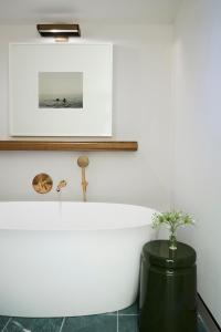 a white bath tub sitting next to a white sink at Kimpton Saint George Hotel, an IHG Hotel in Toronto
