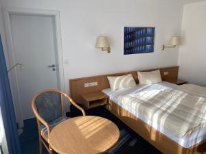1 dormitorio con 1 cama, 1 mesa y 1 silla en Mirage City Hotel Stuttgart Zentrum, en Stuttgart