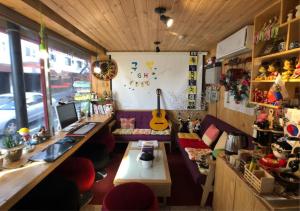 Cette chambre comprend un bureau, un ordinateur et une guitare. dans l'établissement Gudeok Guesthouse, à Seogwipo