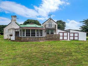 an old house on a grass field in front at The Stables in Port Fairy