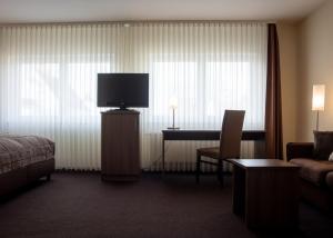 Una televisión o centro de entretenimiento en Hotel Germania