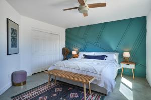 1 dormitorio con cama y pared azul en The Cherokee House in Joshua Tree en Joshua Tree