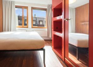 a bedroom with two beds and a large window at Generator Stockholm in Stockholm