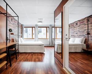 a hotel room with two beds and a desk and a bedroom at Generator Stockholm in Stockholm