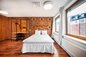a bedroom with a bed and a desk and a window at Generator Stockholm in Stockholm