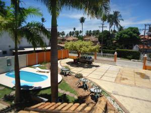 um quintal com piscina e palmeiras em Vale Verde Praia Hotel em Porto Seguro
