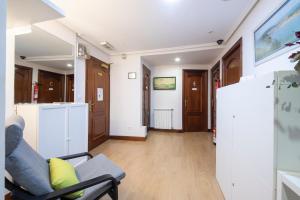 a living room with a chair and a refrigerator at Pensión Santa Clara in Donostia-San Sebastián +16 photos