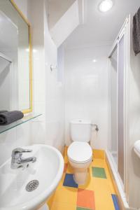 a bathroom with a white toilet and a sink at Pensión Santa Clara in San Sebastián
