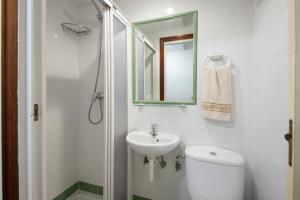 y baño con aseo, lavabo y espejo. en Pensión Santa Clara, en San Sebastián