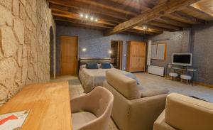 a bedroom with a bed and a couch and a table at La Chambre D'amis LA COSTIGNIERES in Montgueux