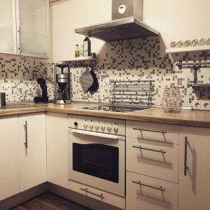 une cuisine avec des armoires blanches et un four à plaques de cuisson dans l'établissement Ferienhaus am Hahnenkopf, à Rübeland