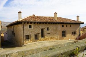 an old stone house with a fence in front of it at Hotel La Val in Jarque de la Val