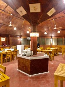 a restaurant with wooden tables and chairs and a counter at Bangaram Island Beach Resort in Bangaram Island