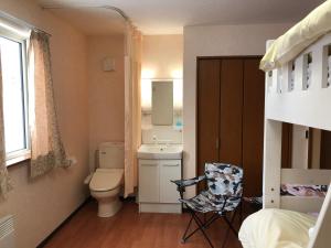 a small bathroom with a toilet and a sink at Alpine Guesthouse in Furano