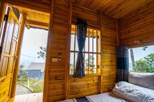 Holzzimmer mit einem Bett und einem Fenster in der Unterkunft Hoa Chanh Bungalow in Sa Pa