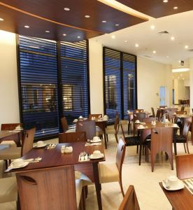 a restaurant with wooden tables and chairs and windows at BRITS HOTEL PANGKALAN BUN in Pangkalan Bun