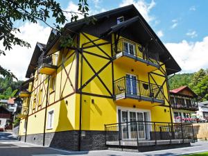 a yellow building with a black roof at Willa Szczepaniakówka in Szczawnica