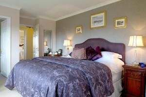 a hotel room with a bed and a dresser at Tyn Rhos Country House in Caernarfon