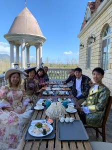 een groep mensen die rond een houten tafel zitten bij 谷築石苑 in Fengli