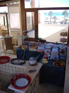 a table with a blue table cloth with food on it at H- Rooms La Darsena in San Vito lo Capo