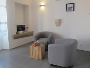 uma sala de espera com duas cadeiras e uma televisão em L'Esperluette em Suze-la-Rousse