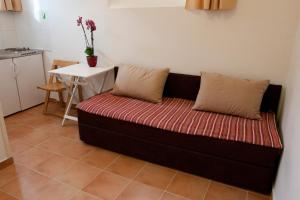 un sofá con 2 almohadas sentado en una habitación en Studio Mary, en Split