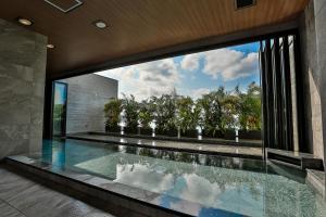 a swimming pool in a house with a large window at Hiyori Ocean Resort Okinawa in Onna