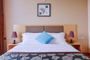 a bedroom with a large bed with blue pillows at Season Paradise in Thulusdhoo