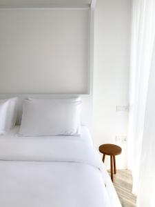 a white bedroom with a bed and a table at Harding Boutique Hotel in Ahangama