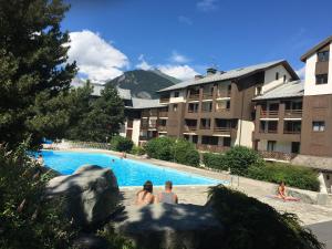 a group of people sitting in a swimming pool at a hotel at studio Les Glieres in Bourg-Saint-Maurice