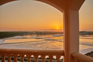 uma vista para o pôr-do-sol a partir da varanda de um resort em Boutiquehotel El Coto em Colonia Sant Jordi