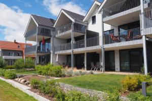 an apartment building with a lawn in front of it at Weisses Haus Plau in Plau am See