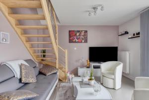 a living room with a couch and a staircase at Rose des Vents in Damgan
