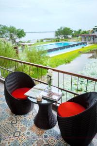 a balcony with two chairs and a table with a view at Baan Rim Ao in Chanthaburi