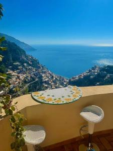 a view of the ocean from a balcony with two stools at La casa del Capitano B&b in Positano