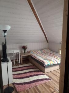 um quarto com uma cama e um tapete em FAZENDA - Przytulne pokoje na krańcu świata em Krynki