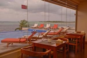 a restaurant with chairs and tables and a swimming pool at Season Paradise in Thulusdhoo