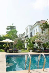 una piscina con una casa en el fondo en Vimean Sovannaphoum Resort en Battambang