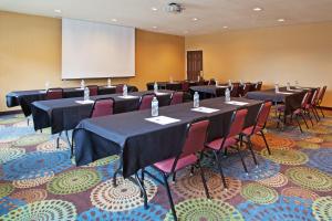 una sala de conferencias con mesas, sillas y una pantalla en Holiday Inn Express & Suites Columbus East - Reynoldsburg, an IHG Hotel, en Reynoldsburg