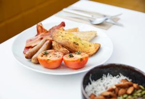 um prato branco de comida com tomate bacon e torradas em Holiday Inn Express Newcastle, an IHG Hotel em Newcastle
