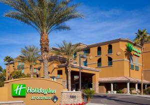 钱德勒Holiday Inn Phoenix/Chandler by IHG的一栋建筑前有棕榈树的酒店