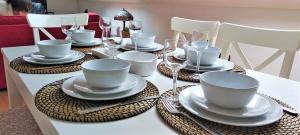 a table with plates and cups and wine glasses at Apartamentos O Almacen in Finisterre