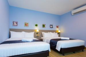 two beds in a room with blue walls at DK Hotel in Johor Bahru