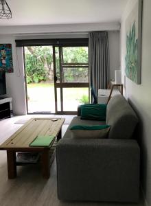 a living room with a couch and a table at Bar Harbor in Papamoa