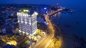洞海的住宿－Riverside Hotel Quang Binh，一座高大的白色建筑,上面有灯