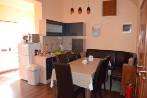 uma cozinha e sala de jantar com mesa e cadeiras em Holdfényszállás em Szeged